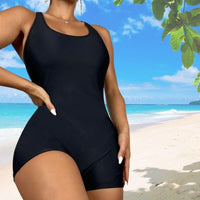 Maillot de Bain Shorty Gainant noir sur une plage, silhouette sculptée et style moderne.