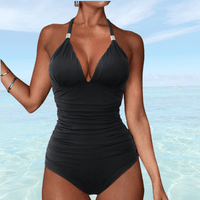 Maillot de bain noir gainant, femme de face, silhouette amincissante au bord de la mer.